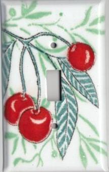 A handmade single toggle fused glass switch plate cover with the image of cherries.